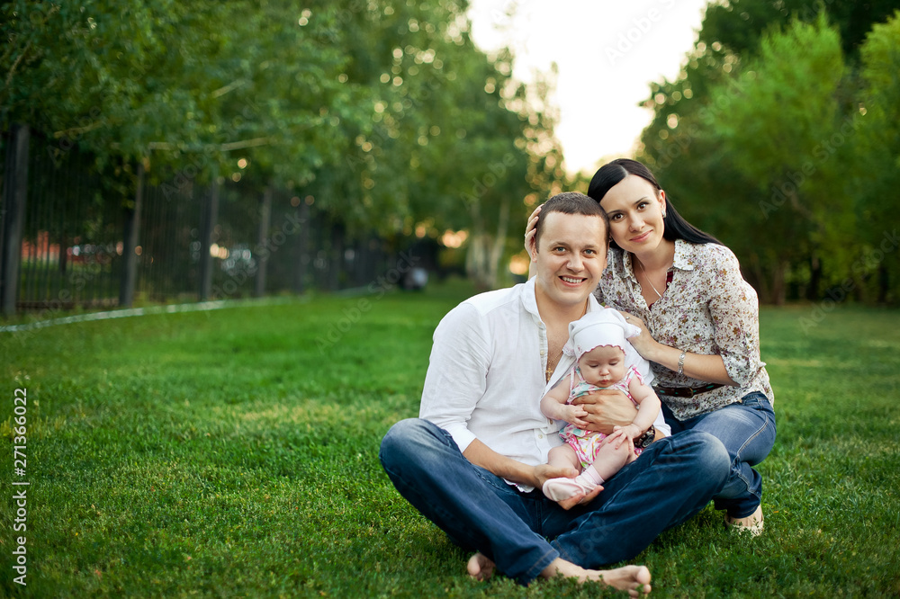 Happy family mother, father, child daughter. Happy young family spending time together outside in green nature. Happy family resting together on the green grass. Happy family having fun outdoors Happy family mother, father, child daughter. Happy young family spending time together outside in green nature. Happy family resting together on the green grass. Happy family having fun outdoors