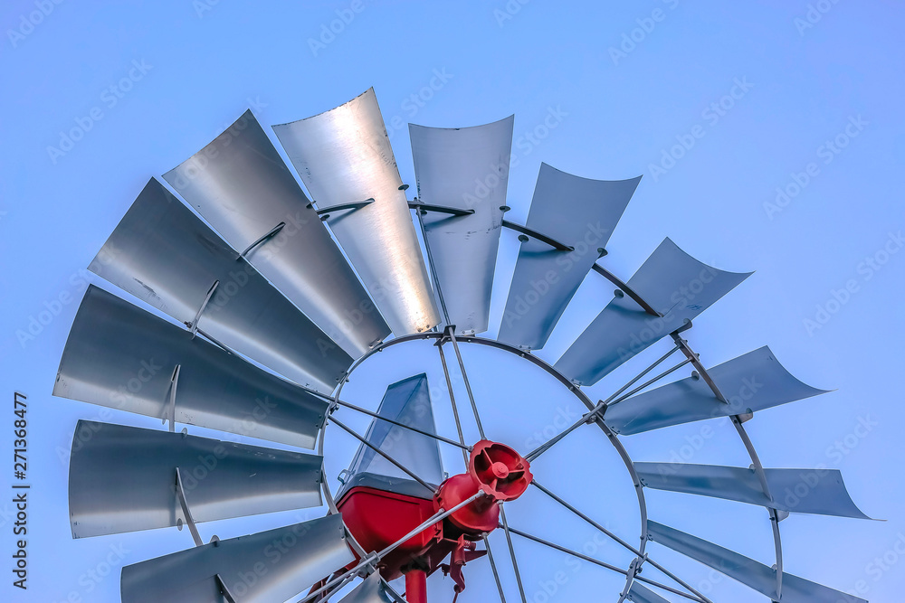 Close up of a steel windpump with pale blue sky in the background