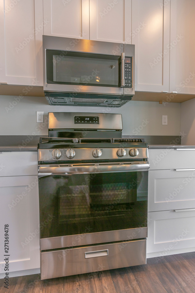 Fototapeta premium Range and wall mounted microwave inside the modern kitchen of a new house