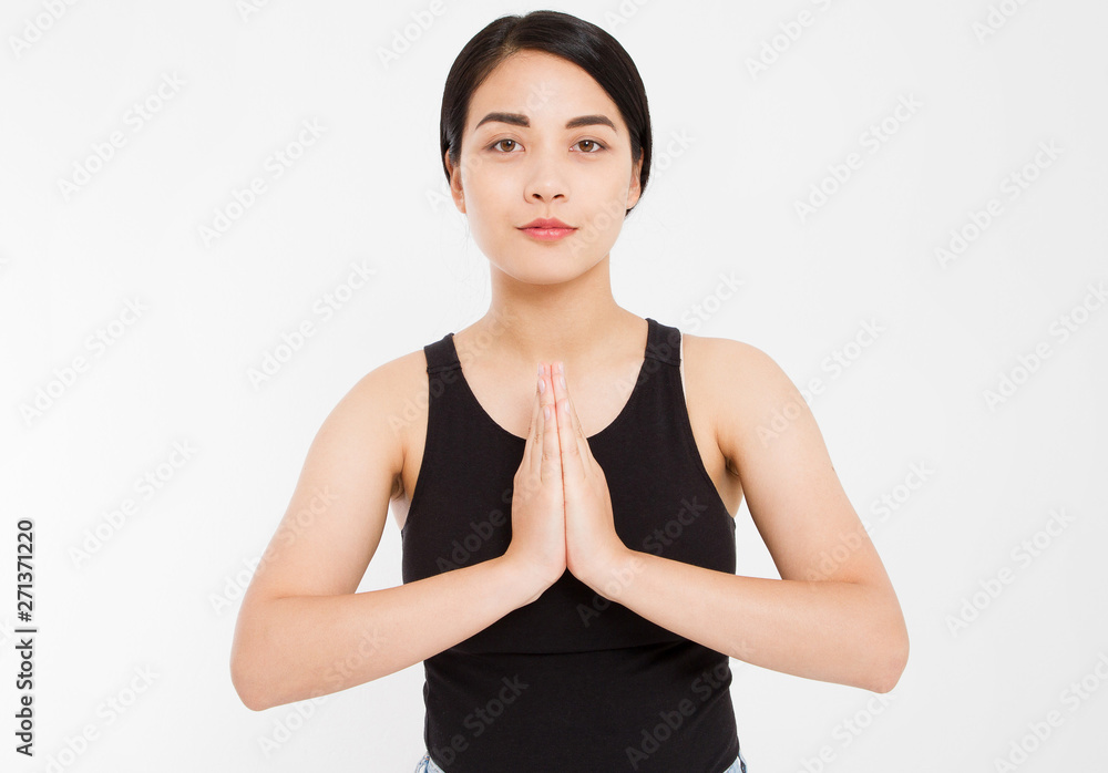 Namaste, friends. Portrait of friendly-looking happy asian female student in casual clothes, holding palms in pray and smiling broadly while making buddhist greeting or praying over gray wall Namaste, friends. Portrait of friendly-looking happy asian female student in casual clothes, holding palms in pray and smiling broadly while making buddhist greeting or praying over gray wall