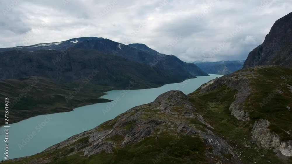 Drone view behind the mountain on the blue green river in Norway Drone view behind the mountain on the blue green river in Norway