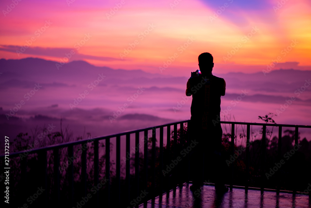 Men take pictures with a smartphone on the balcony morning view on the mountain,Khao Khai Nui, Phang Nga Thailand, Thailand.