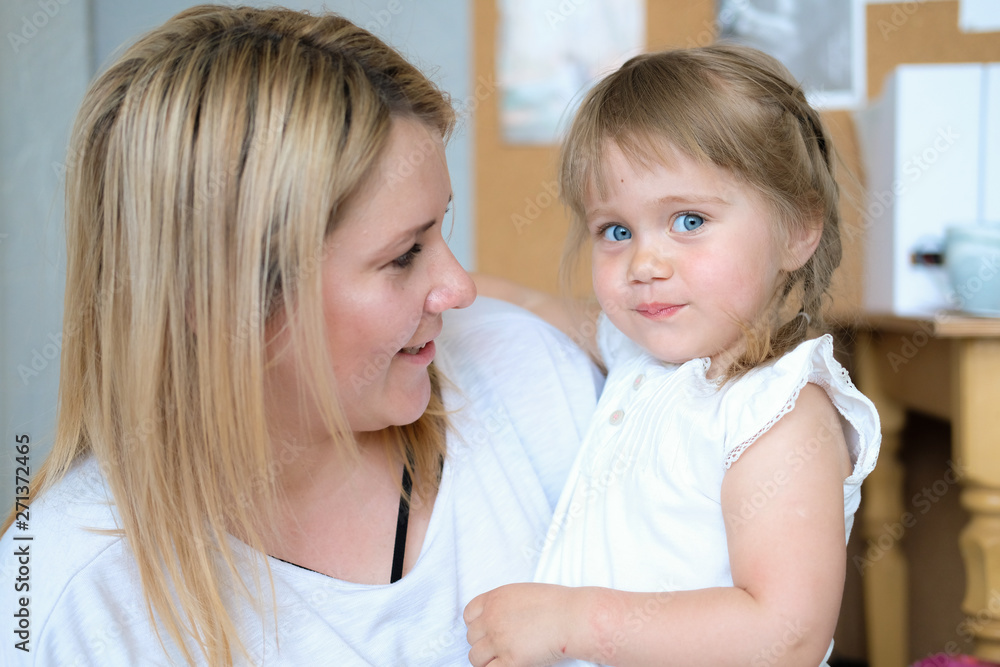 Mother and doughter. A young blonde woman with her beautiful little daughter. The girl has blue eyes and blonde braids. Mother and doughter. A young blonde woman with her beautiful little daughter. The girl has blue eyes and blonde braids.