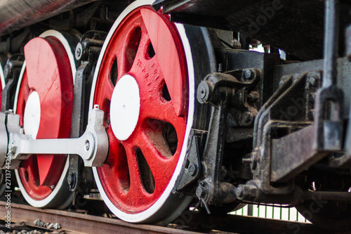 Outdoor transport, red-black painted vintage steam train driving wheel close-up