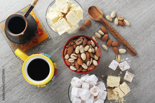 A mug of coffee and different oriental sweets: turkish delight, halva, almond and pistachio