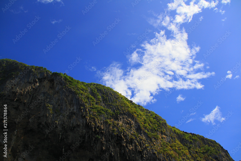 Mountain rock in middle of sea with blue sky and cloud, very happy every time when seeing.