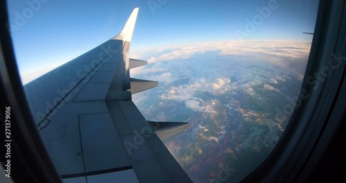 A time lapse view from an airplane window. From Daytime until night, we fly over the clouds and the earth. photo