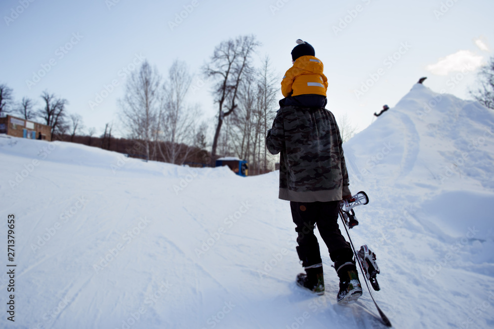 the snowboarder goes up the hill with the child
