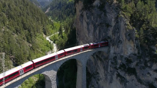 Landwasser viaduct, red train on the railway. Unesco World Heritage. Aerial view 4k photo
