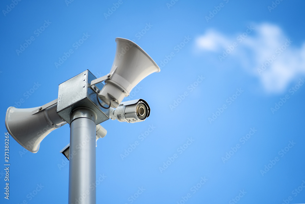 Security camera with loudspeakers and megaphone on the sky background Security camera with loudspeakers and megaphone on the sky background