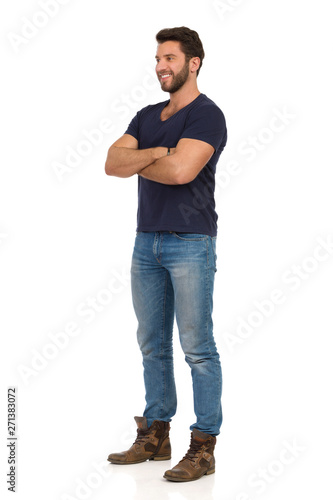 Smiling Handsome Man In Jeans, Boots And Blue T-shirt Is Standing With Arms Crossed © studioloco