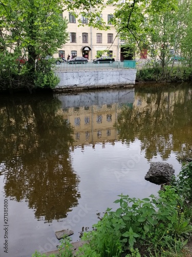 reflection of houses and trees on the river in St. Petersburg 