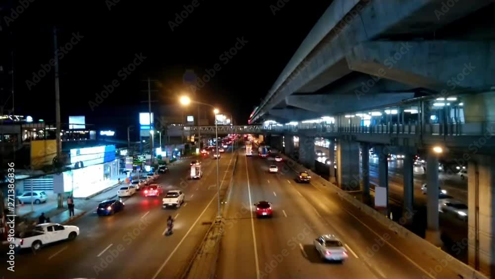 Cars driving on the road at night With the light shining and people walk on the sidewalk. Cars driving on the road at night With the light shining and people walk on the sidewalk.