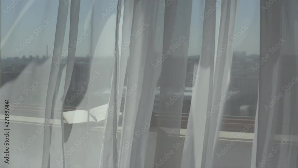 Open agenda with a pen at marble sill of an open window. Blowing grey transparent curtains Open agenda with a pen at marble sill of an open window. Blowing grey transparent curtains