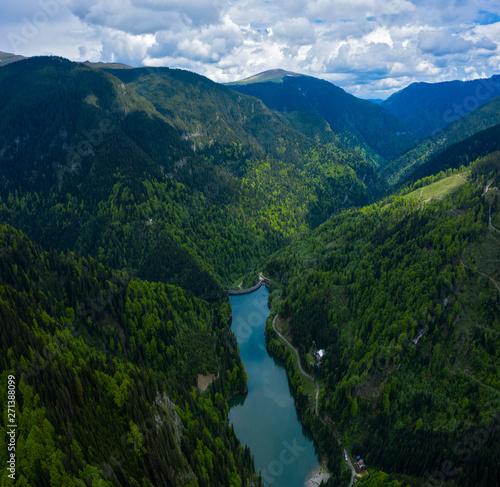 Aerial drone shot of a lake and green forest in Transylvania, Romania