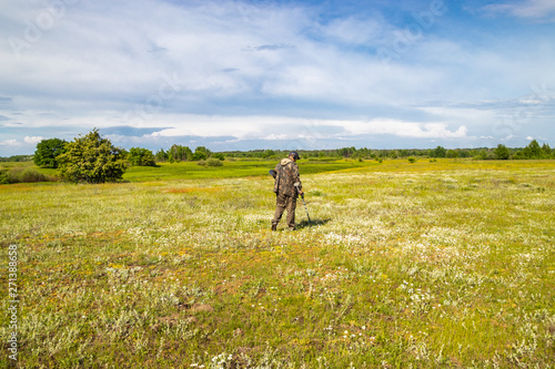 Treasure hunter in the field with a metal detector © Taras