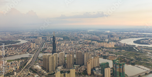 Fototapeta Naklejka Na Ścianę i Meble -  Top View of Building in a City - Aerial view Skyscrapers flying by drone of Ho Chi Mi City with development buildings, transportation, energy power infrastructure.