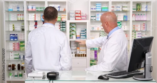 Two Pharmacist Colleague Talking About Medicine Stock Inside a Pharmacy