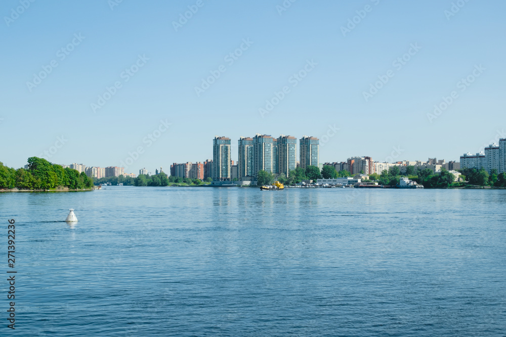 Obraz premium View of the city from the other side of the river. Beautiful landscape on the river during the daytime.