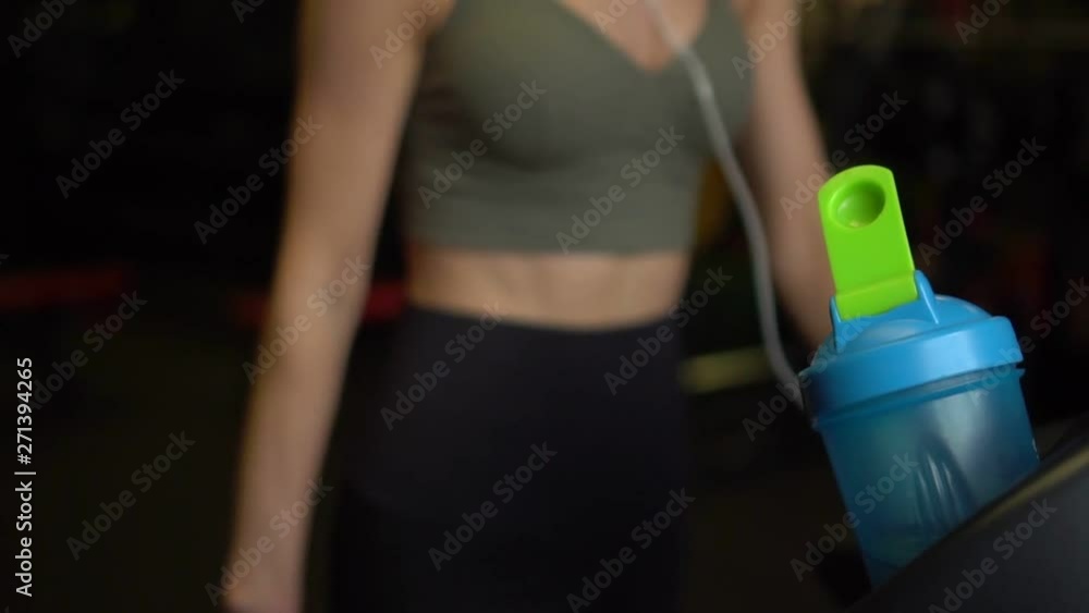 Beautiful Woman Athlete Runs on a Treadmill Slow Motion. Out of Focus. Beautiful view. Beautiful Woman Athlete Runs on a Treadmill Slow Motion. Out of Focus. Beautiful view.