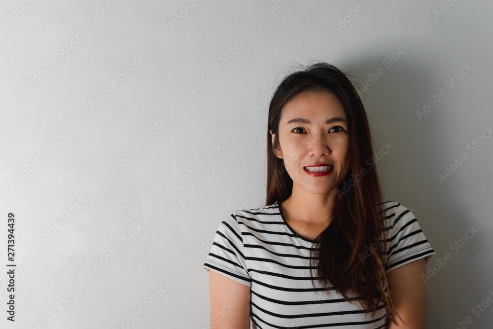 Beautiful young asian woman smiling on wall background. Beautiful young asian woman smiling on wall background.