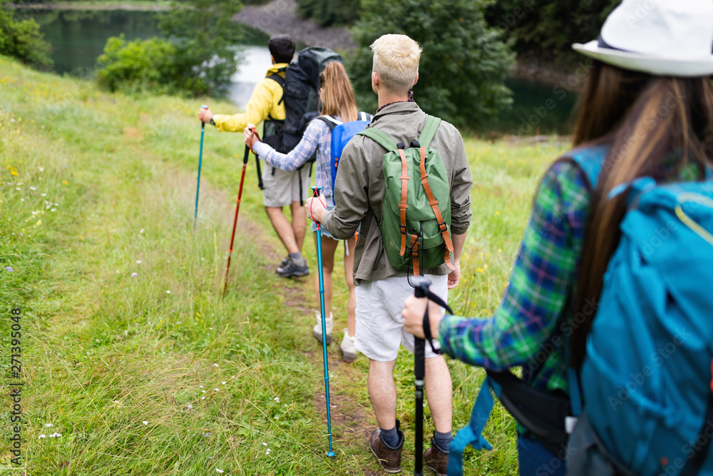 © NDABCREATIVITY - Group of happy friends with backpacks hiking together © NDABCREATIVITY - Group of happy friends with backpacks hiking together