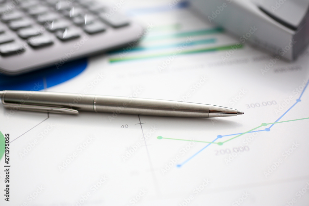 Silver pen and calculator at workplace ready to be used Silver pen and calculator at workplace ready to be used