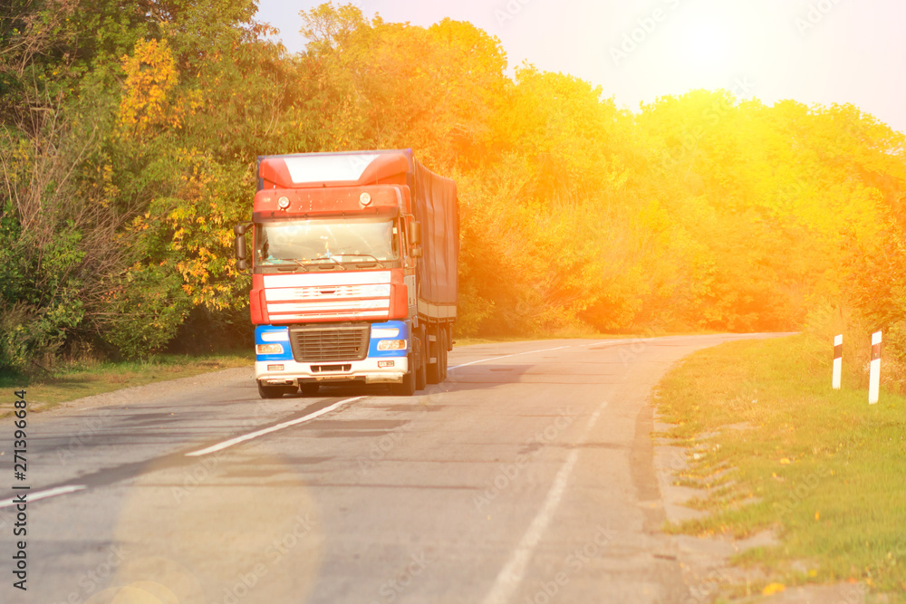 Truck on road with white blank container, shipping, delivery and cargo transportation concept at sunset