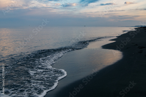 Black magnetic sand beach of Black sea in Ureki, Georgia.Sunset in a cloudy sky on the sea.Rest on black sea.trip to the sea of Georgia
