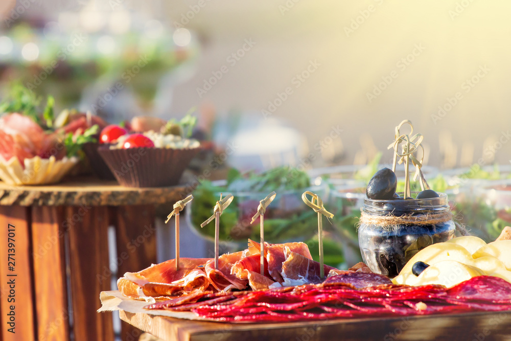 Beautifully decorated catering banquet table with different food snacks and appetizers with sandwich, caviar, fresh fruits on corporate christmas birthday party event or wedding celebration Beautifully decorated catering banquet table with different food snacks and appetizers with sandwich, caviar, fresh fruits on corporate christmas birthday party event or wedding celebration