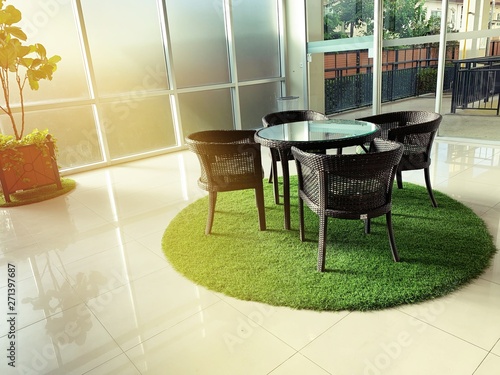 interior furniture, table set for dining decorating with artificial grass circle shape on the floor, interior design decoration concept in the building. 