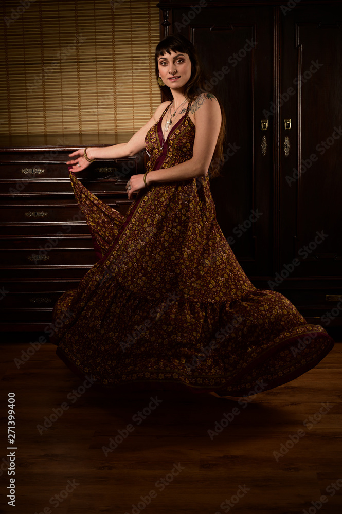 Fototapeta premium Young girl dancer and singer in gypsy dress dancing and posing on stage