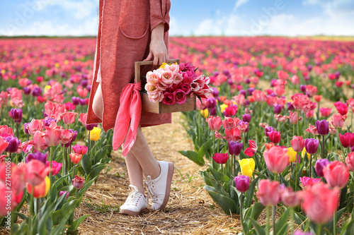 Foto Beautiful young woman in tulip field on spring day