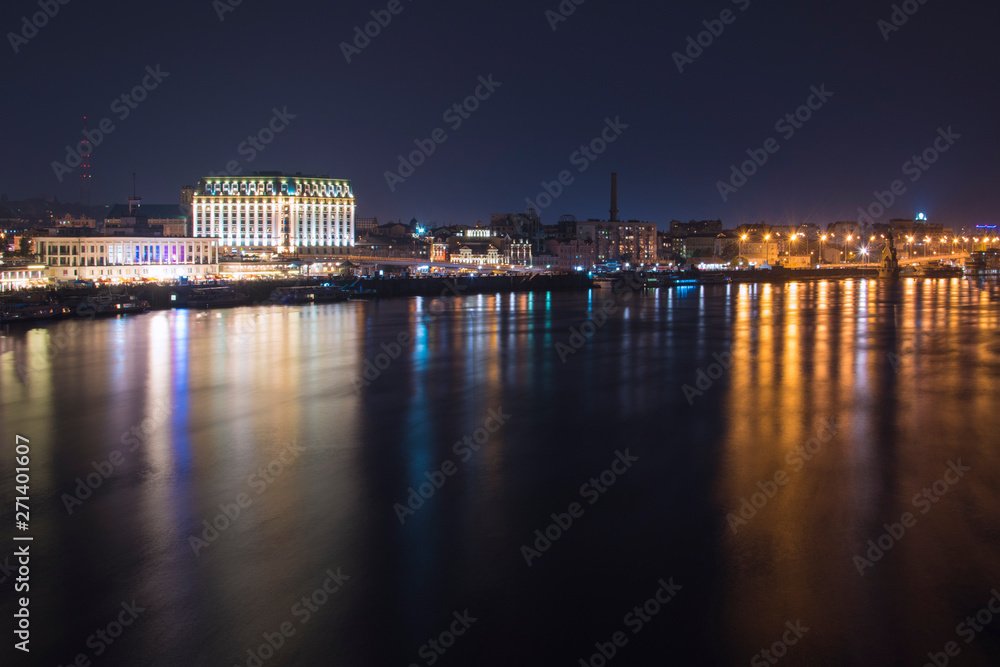 Kiev city in Ukraine at night beside the rive with reflection in water