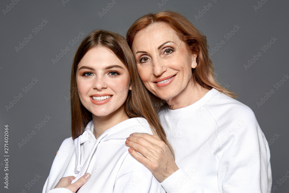 Portrait of happy mother with her daughter on grey background Portrait of happy mother with her daughter on grey background