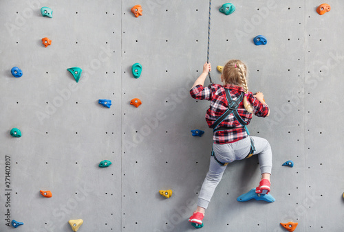 Little girl climbing wall i...