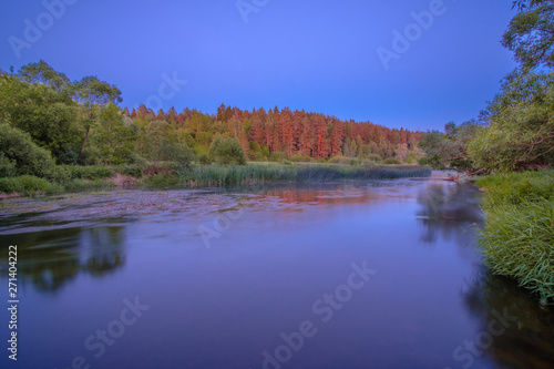 Picturesque Central Russian landscape with a thin layer of fog creeping along the forest along the river bank.  © Nekrasov