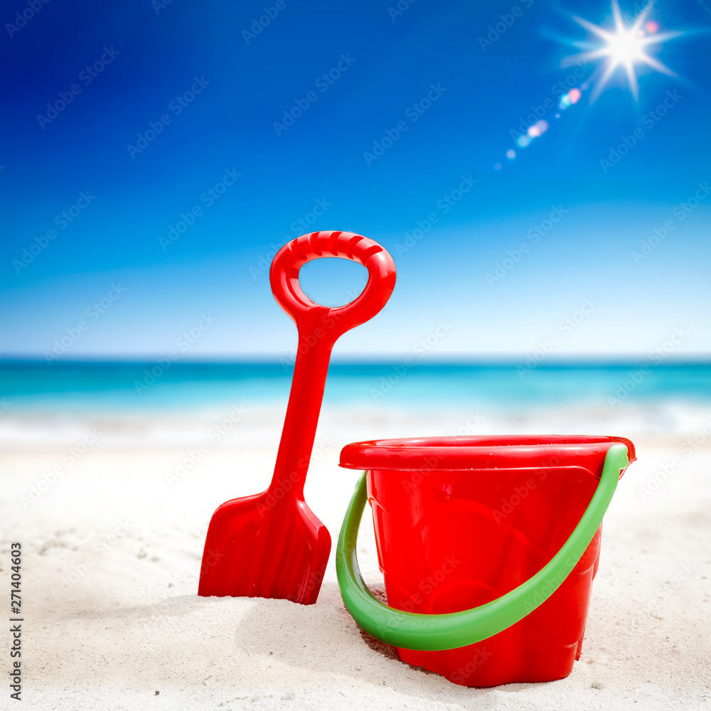 Red plastic bucket with free space for your product. The possibility of mounting bottles with drink, ice cream, food or other products. Blurry beach with people and ocean view. Red plastic bucket with free space for your product. The possibility of mounting bottles with drink, ice cream, food or other products. Blurry beach with people and ocean view.