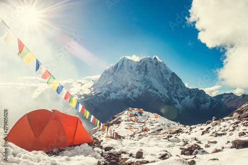 Bright orange tent  and prayer flags in the Everest base camp. Mountain peak Everest. Highest mountain in the world. National Park, Nepal. photo