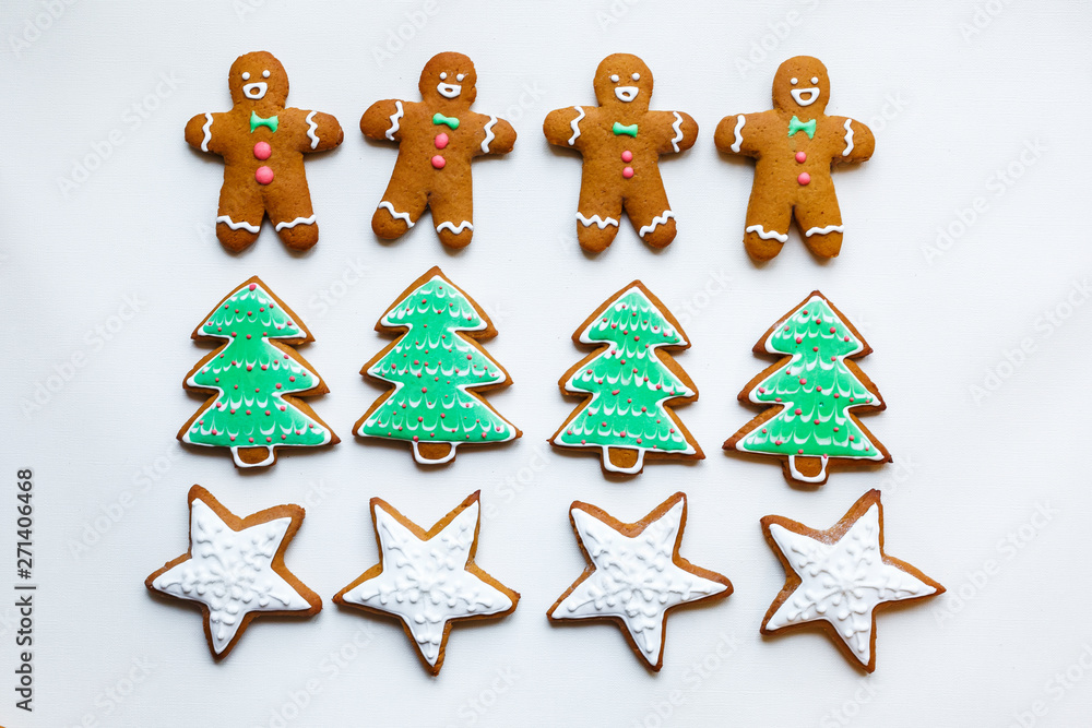 Handmade festive gingerbread cookies in the form of stars, snowflakes, people, socks, staff, mittens, Christmas trees, hearts for xmas and new year holiday on white paper background