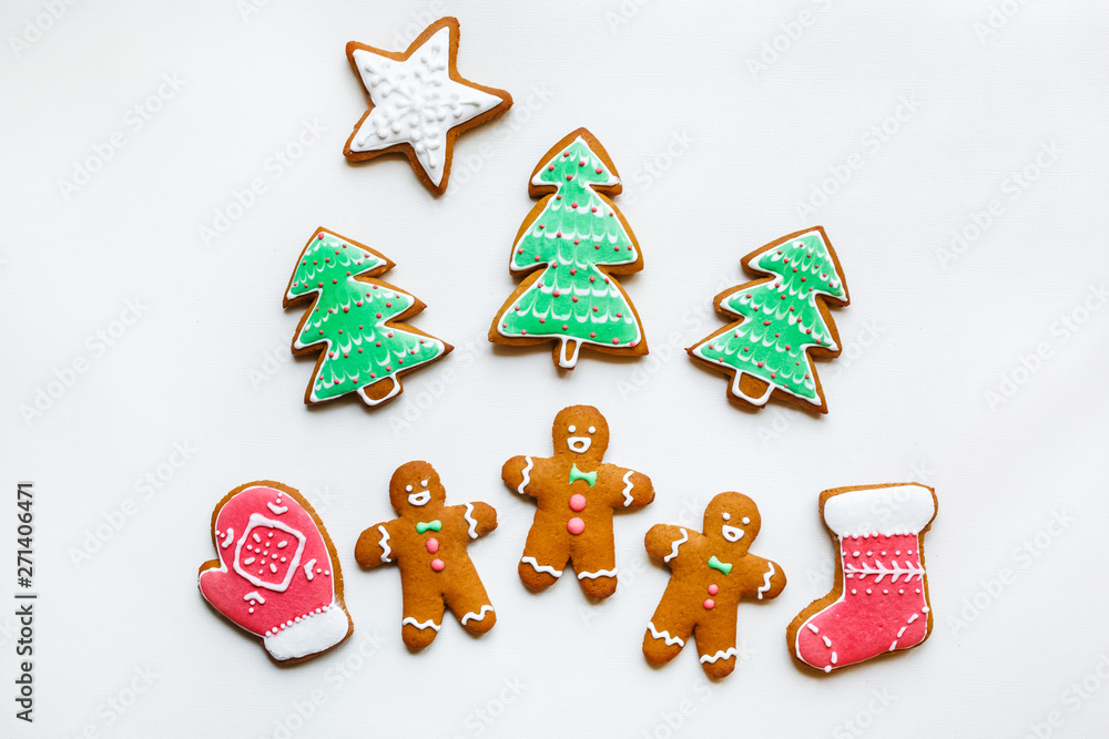 Fototapeta Handmade festive gingerbread cookies in the form of stars, snowflakes, people, socks, staff, mittens, Christmas trees, hearts for xmas and new year holiday on white paper background