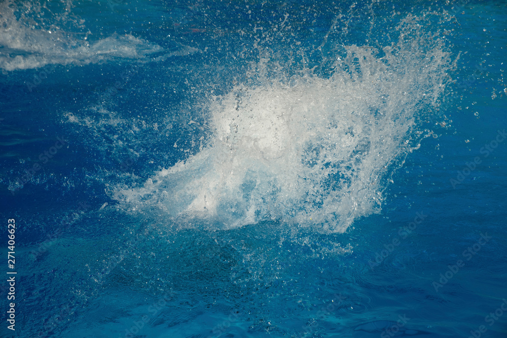 Powerful splash on a blue water surface with waves and splashes.