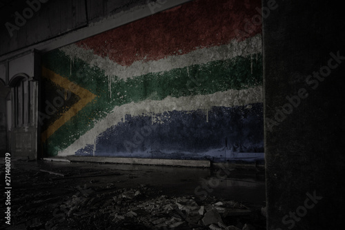 painted flag of south africa on the dirty old wall in an abandoned ruined house.