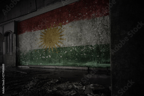painted flag of kurdistan on the dirty old wall in an abandoned ruined house. photo
