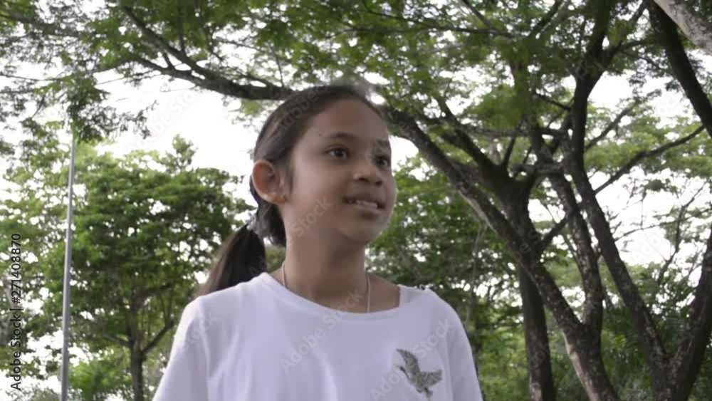 Young cute girl walking on the pathway in public park, Slow motion. Young cute girl walking on the pathway in public park, Slow motion.