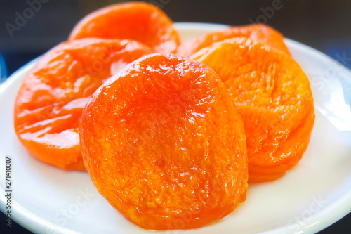 dried apricots close up on a white plate and dark background