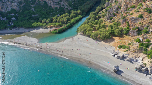 Aerial drone view of Mediterranean paradise river with palm trees flowing to sandy deep turquoise beach © aerial-drone
