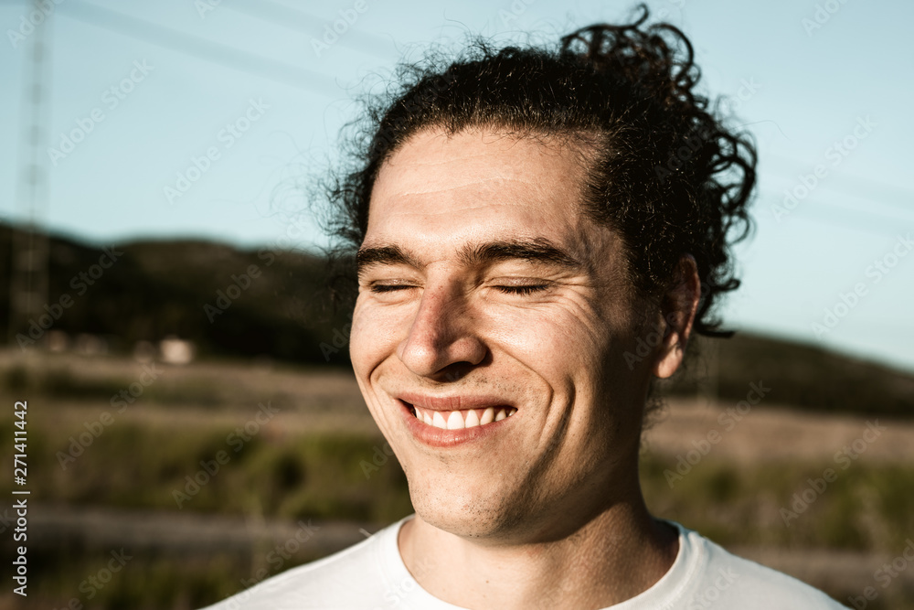 Handsome guy smiling with long hair and curls Handsome guy smiling with long hair and curls