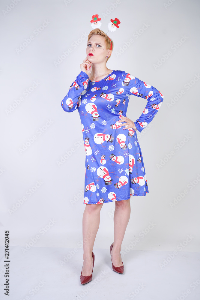 pretty blonde girl with short hair wearing christmas funny bright dress on white studio background alone pretty blonde girl with short hair wearing christmas funny bright dress on white studio background alone