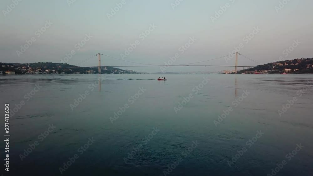 drone flying towards a small boat on Bosporus, Istanbul, early morning, FSM bridge in view, low altitude, sm01 drone flying towards a small boat on Bosporus, Istanbul, early morning, FSM bridge in view, low altitude, sm01